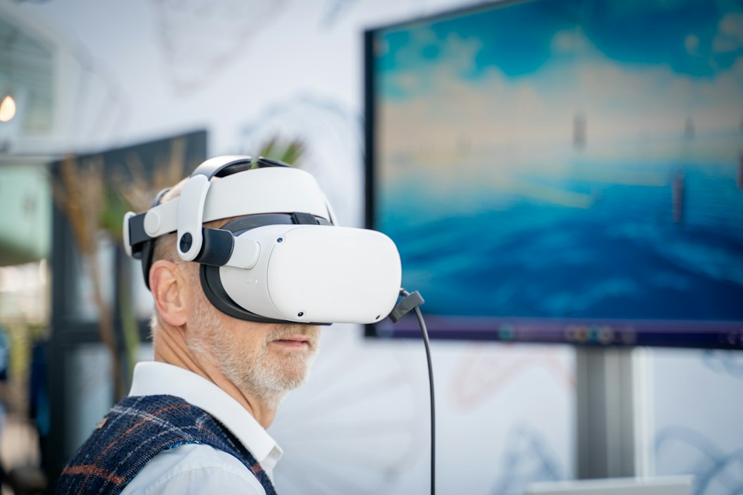 A person in front of a laptop working on a virtual reality environment