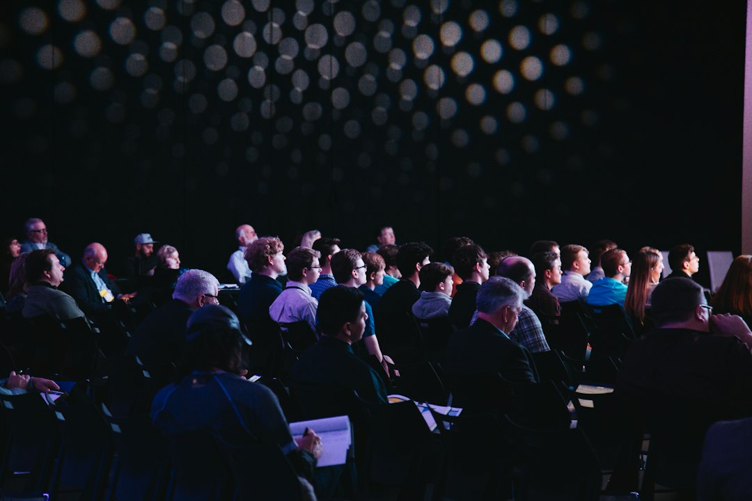 An audience seated in a presentation hall at a virtual reality technology conference